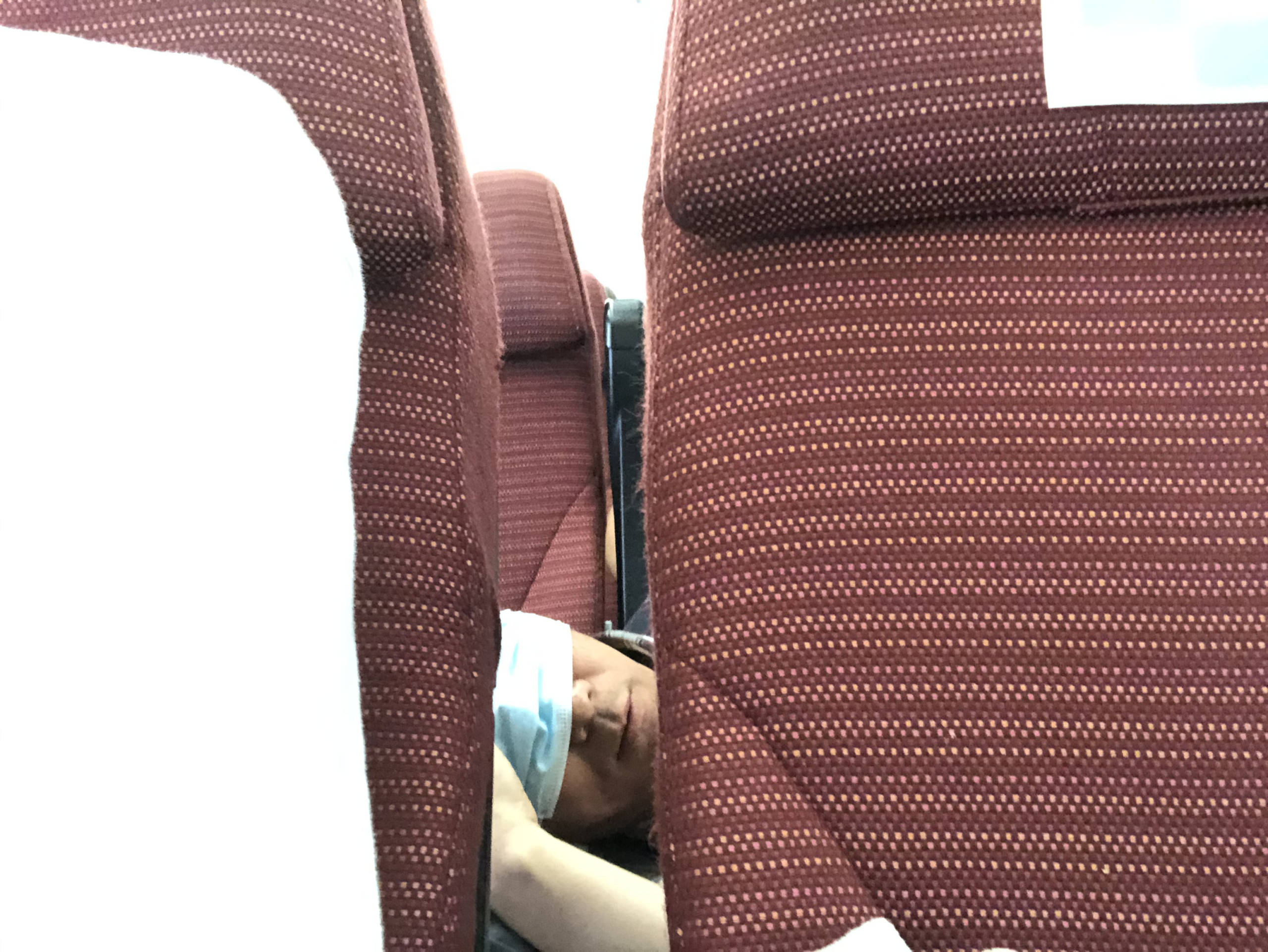 Señor utilizando la mascarilla como antifaz en un vuelo de Londres a Tokio de JAL